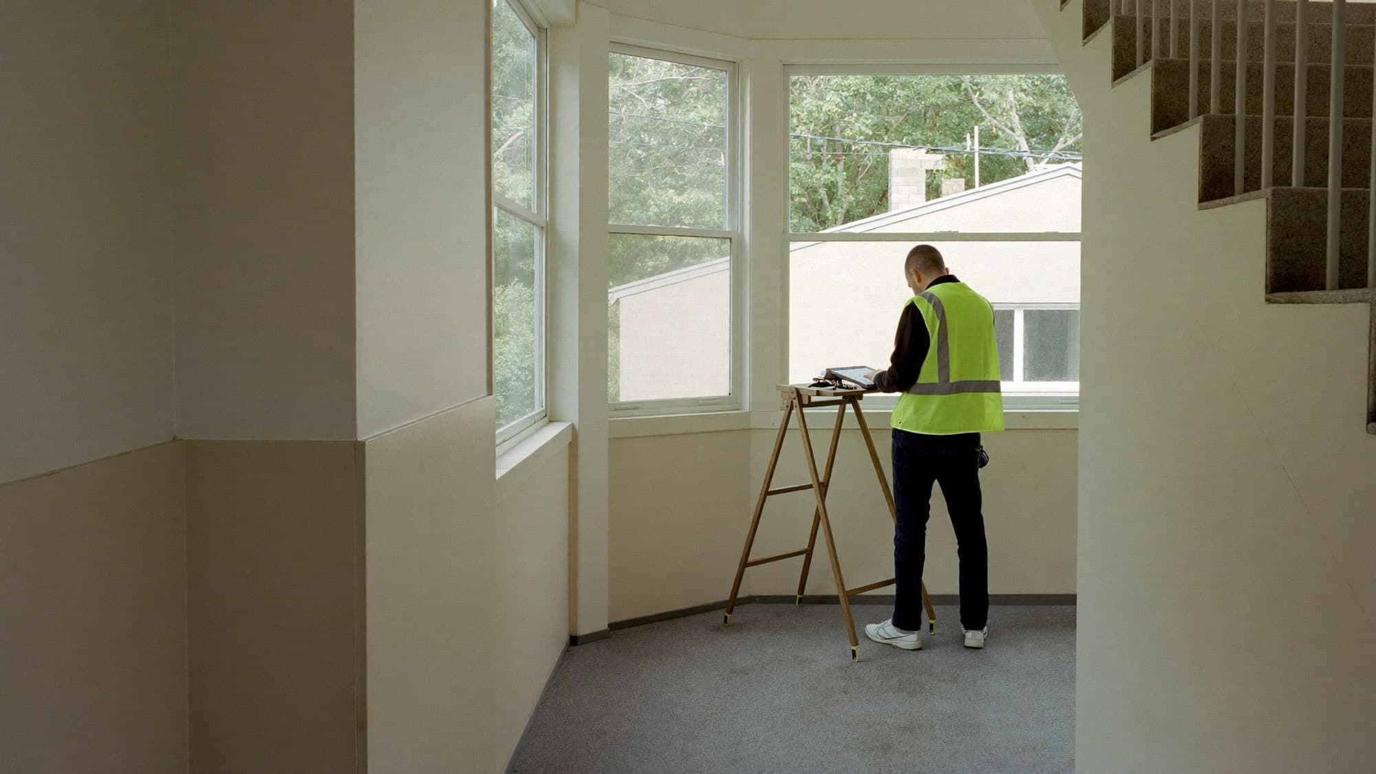 Surveyor working offline in a communal stairwell of a housing block.